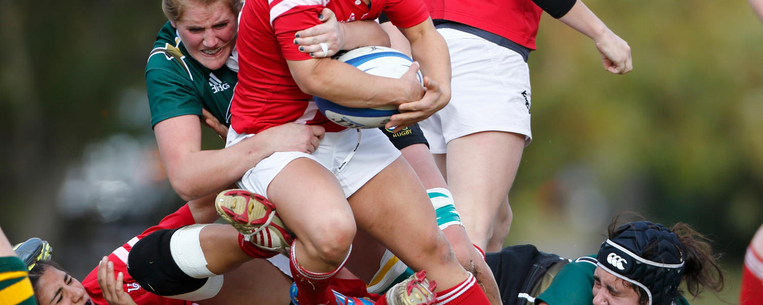 Female rugby dino players in a tackle