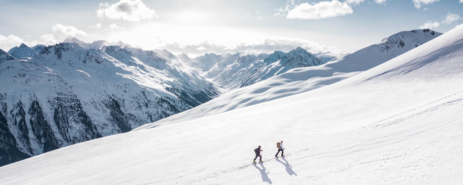 two people ski touring in the mountains